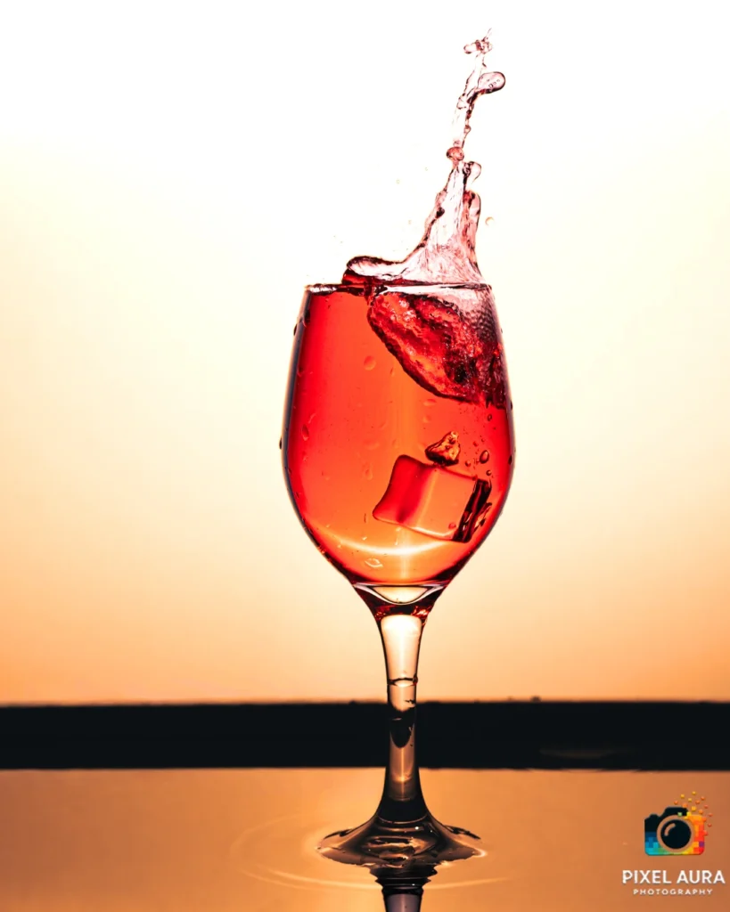 Red drink photographed with a splash in a wine glass